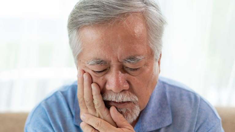 Older asian man holding his jaw in pain, los gatos ca